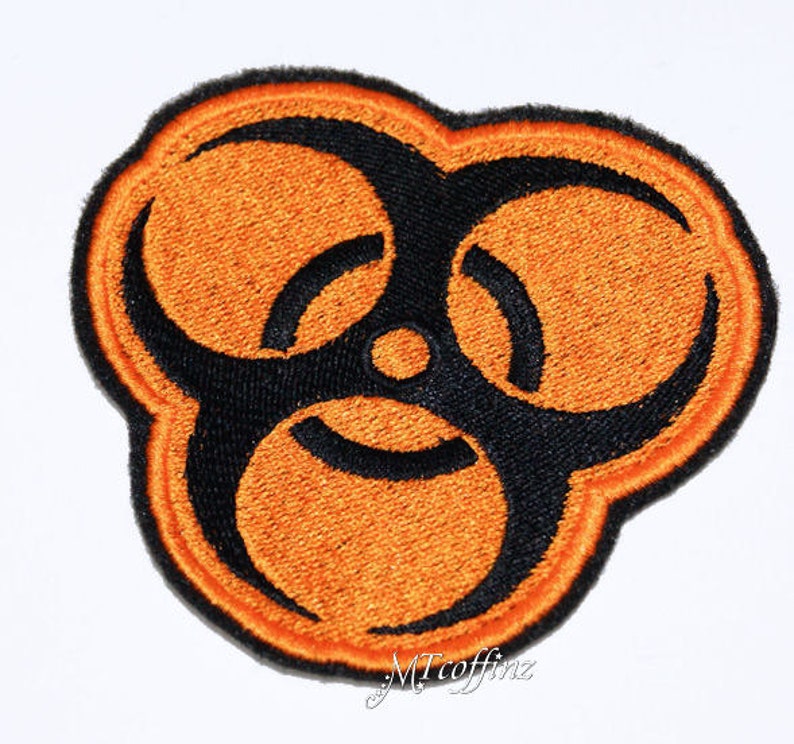 May include: Orange and black embroidered patch with a biohazard symbol.