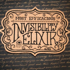 May include: A brown and black embroidered patch with a decorative border. The patch features the text "MOST EFFICACIOUS INVISIBILITY ELIXIR" with a stylized eye and a small arrow.