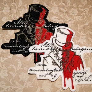 May include: Two embroidered patches with a black and white illustration of a person wearing a top hat. The person is split in half, with one side red and the other white. The text on the patches reads "All human beings are commingled out of good and evil."