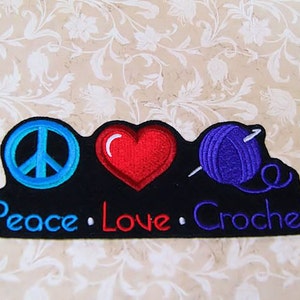 May include: A black patch with the words "Peace. Love. Crochet" in white, blue, and red lettering. A blue peace sign, a red heart, and a purple yarn ball with a needle are depicted on the patch.