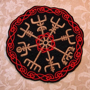 May include: A black felt patch with a gold embroidered Vegvisir symbol surrounded by a red Celtic knot border.