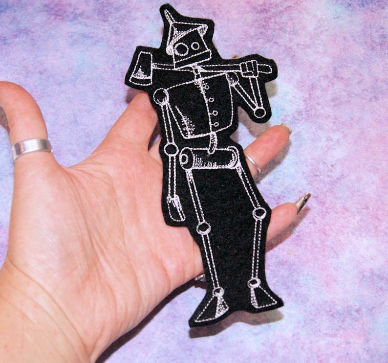 May include: White embroidered iron man with an axe on a black felt patch.