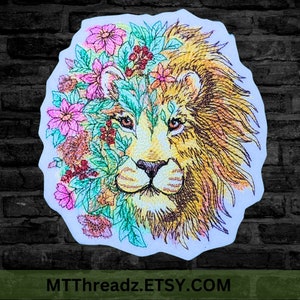 May include: Embroidered design of a lion's face with a floral wreath around its head. The lion is depicted in shades of yellow and brown, while the flowers are pink, red, and green.