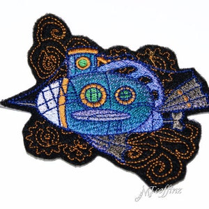 May include: Embroidered patch of a blue submarine with gold accents and green portholes, surrounded by black and gold swirling designs.