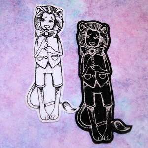 May include: Two embroidered iron-on patches of a lion wearing a vest and bow tie. One patch is white with black outlines and the other is black with white outlines.