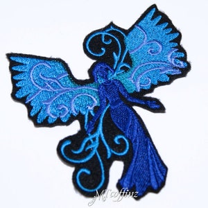 May include: Blue and teal embroidered iron-on patch of a fairy with wings and a floral design.