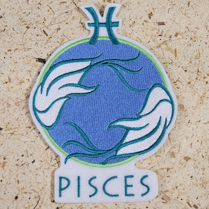 Peut inclure: Un patch thermocollant brodé en bleu et blanc avec le symbole astrologique des Poissons et le mot "Poissons" en dessous.