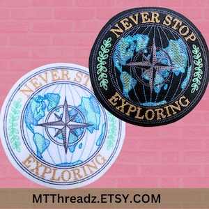 May include: Two embroidered patches with a compass and a globe design. The text on the patches reads "Never Stop Exploring".