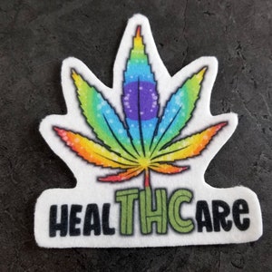 Puede incluir: Una pegatina blanca con una hoja de marihuana arcoíris y el texto "HEALTHCARE" en letras negras con un "TH" verde en el medio.