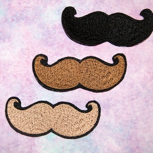 May include: Three embroidered felt mustache patches in black, brown, and light brown. The patches are all the same size and shape, with a classic mustache design.