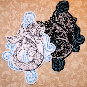 May include: Two embroidered iron-on patches featuring a mermaid with flowing hair and a tail, surrounded by stylized waves. One patch is black and white, the other is white with blue accents.