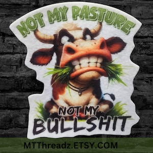 May include: A white patch featuring a cartoon cow with a red and white face, green grass in its mouth, and the text "NOT MY PASTURE NOT MY BULLSHIT" in black. The text "MTTThreadz.ETSY.COM" is at the bottom of the patch.