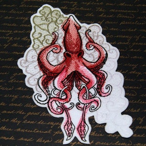 May include: Embroidered patch featuring a red squid with white and silver details. The squid is depicted with tentacles curled around its head and a swirling background.