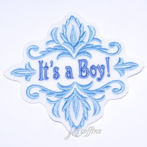 May include: Blue and white embroidered iron-on patch with a decorative design and the text "It's a Boy!"