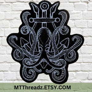 May include: Black and white embroidered patch featuring an anchor with a trident above it. The anchor and trident are surrounded by stylized waves. The patch is made of felt and has a stitched edge.