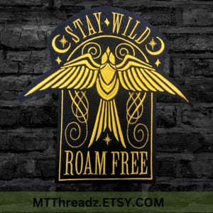 May include: Black embroidered patch with a gold bird design and the text "Stay Wild Roam Free".