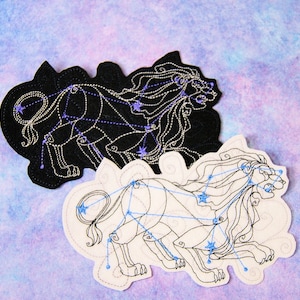 May include: Two embroidered patches depicting the constellation Leo, the lion. One patch is black with white stitching, the other is white with black stitching. Both patches feature a stylised lion with a constellation of stars.