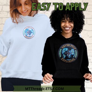May include: Two hooded sweatshirts with a blue and green embroidered patch that says "Never Stop Exploring" and features a compass and a globe. The sweatshirts are light blue and black.