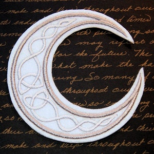 May include: A white crescent moon patch with a silver embroidered Celtic knot design. The patch has a brown outline and is perfect for adding a touch of Celtic style to your clothing or accessories.