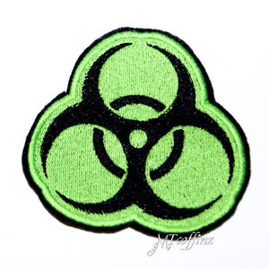 May include: Green and black biohazard symbol patch. The symbol is a stylized triangle with three circles and a black outline.