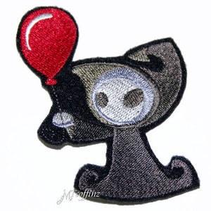 May include: A black and gray embroidered patch of a cartoon character holding a red balloon. The character has a large head with a white face and a small body.