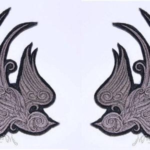 May include: Two black and silver embroidered iron-on patches of stylized flying birds. The birds are detailed with intricate swirls and patterns.