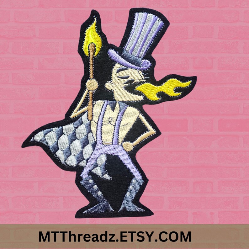 May include: Embroidered iron-on patch featuring a cartoon character with a top hat, flames, and a checkered cape. The character is holding a lit torch. The patch is black, white, purple, and yellow.