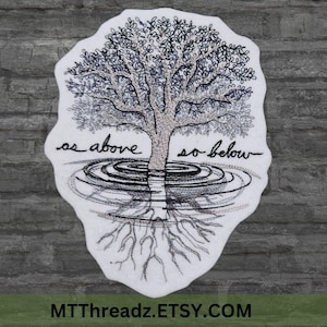 May include: Embroidered design of a tree with roots and branches, surrounded by water ripples. The text "as above so below" is stitched in black thread.