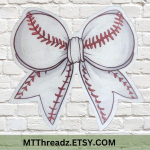 May include: A white baseball-themed bow with red stitching details. The bow is designed to resemble a baseball, with the stitching mimicking the seams. The image includes the text MTThreadz.ETSY.COM.