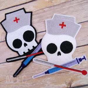 May include: Two white skull embroidered patches with a red cross on a grey nurse's hat. Each skull has black eyes and a crossbones design with a red and blue syringe.