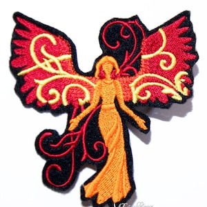 May include: Embroidered iron-on patch featuring a stylized angel with red and orange wings and a black and red floral design. The angel is wearing a long orange dress.