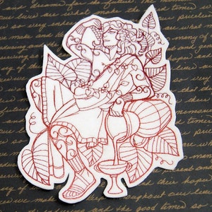 May include: Red embroidered design of a person sitting on a throne with a goblet in their hand. The design is surrounded by leaves and vines.