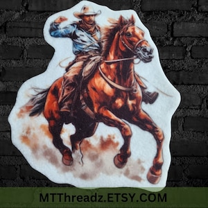 May include: A brown horse with a cowboy riding on its back. The cowboy is wearing a blue shirt, brown pants, and a brown hat. The horse is running and kicking up dust. The image is on a white background.