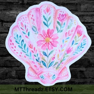 May include: A die-cut sticker shaped like a scallop shell featuring a soft pink watercolor wash. The surface is decorated with hand-painted floral motifs, including a large central pink flower, smaller blossoms, and green leafy vines.