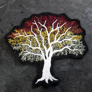 May include: Embroidered iron-on patch of a white tree with a black background. The tree has a red, orange, and yellow gradient of leaves.