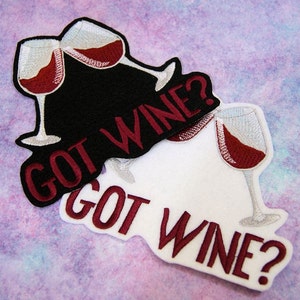 May include: Two embroidered iron-on patches with the text "GOT WINE?" and a design of two wine glasses clinking. One patch is black with white wine glasses and the other is white with silver wine glasses.