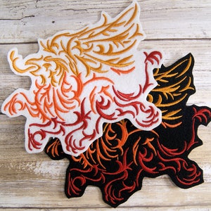 May include: Two embroidered iron-on patches featuring a stylized dragon design. The top patch is white with orange and gold embroidery. The bottom patch is black with orange and red embroidery.