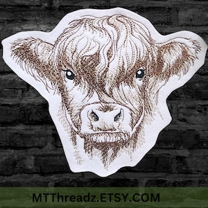 May include: Embroidered patch featuring a Highland cow's face in shades of brown and tan. The cow's face is detailed with intricate stitching, set against a white background. The text "MTThreadz.ETSY.COM" is at the bottom.