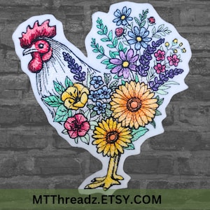 May include: White embroidered rooster with a colorful floral design. The rooster is standing on its two legs and has a red comb and wattle. The flowers are in shades of pink, purple, yellow, and blue.