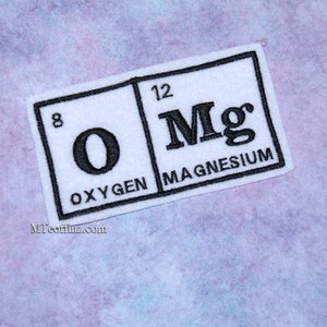 May include: White patch with black text depicting the chemical elements oxygen (O) and magnesium (Mg) with their atomic numbers 8 and 12. The text "Oxygen" and "Magnesium" are written below the elements.