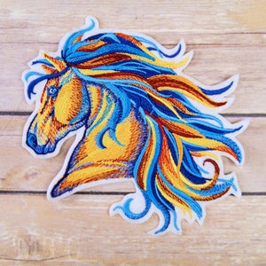 May include: Embroidered patch of a horse's head with a flowing mane in shades of blue, yellow, and red.