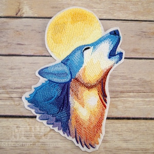 May include: Embroidered patch featuring a howling wolf under a full moon. The wolf is depicted in shades of blue, orange, and yellow, with a yellow moon in the background. The patch is designed for application on clothing or accessories.