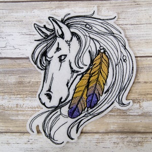 May include: Embroidered iron-on patch of a white horse with a long flowing mane and tail. The horse has a purple and gold feather earring.