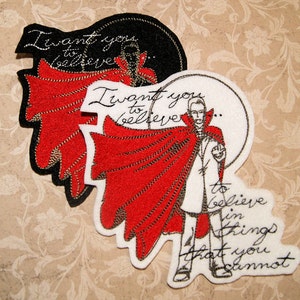 May include: Embroidered patch with a black and white illustration of a person in a red cape and the text "I want you to believe..." and "to believe in things that you cannot"