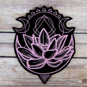 May include: A black embroidered patch featuring a light pink lotus flower design. Above the flower are geometric shapes including a triangle, a circle, and two crescent moons. The text MTCoffinz Designs is visible in the bottom left corner.