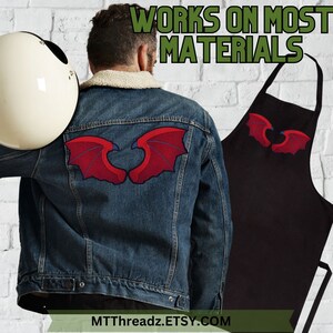 Puede incluir: Un delantal negro con alas bordadas rojas en la parte delantera. El delantal se muestra en una persona que lleva una chaqueta vaquera con las mismas alas bordadas rojas en la espalda. El texto "WORKS ON MOST MATERIALS" se muestra encima del delantal. El texto "MTTthreadz.ETSY.COM" se muestra debajo del delantal.
