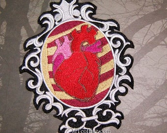 May include: An embroidered iron-on patch featuring a red anatomical heart in a silver and black ornate frame. The heart is surrounded by a striped background in shades of pink, red, and gold.