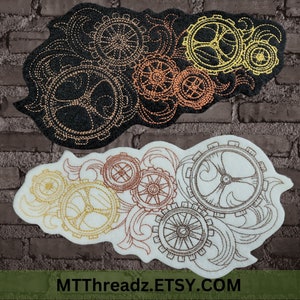 May include: Two embroidered patches featuring a steampunk gear design. One patch is black with gold and copper gears, the other is white with gold, copper, and brown gears. The patches have a decorative, swirling border.