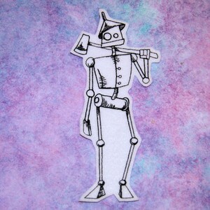 May include: A black and white line drawing of a robot with an axe on its shoulder. The robot is standing on a white background with a purple and blue watercolor wash.