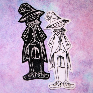 May include: Two black and white embroidered iron-on patches of a whimsical character wearing a hat and a long coat. The character has a stitched-on smile and a stitched-on nose.